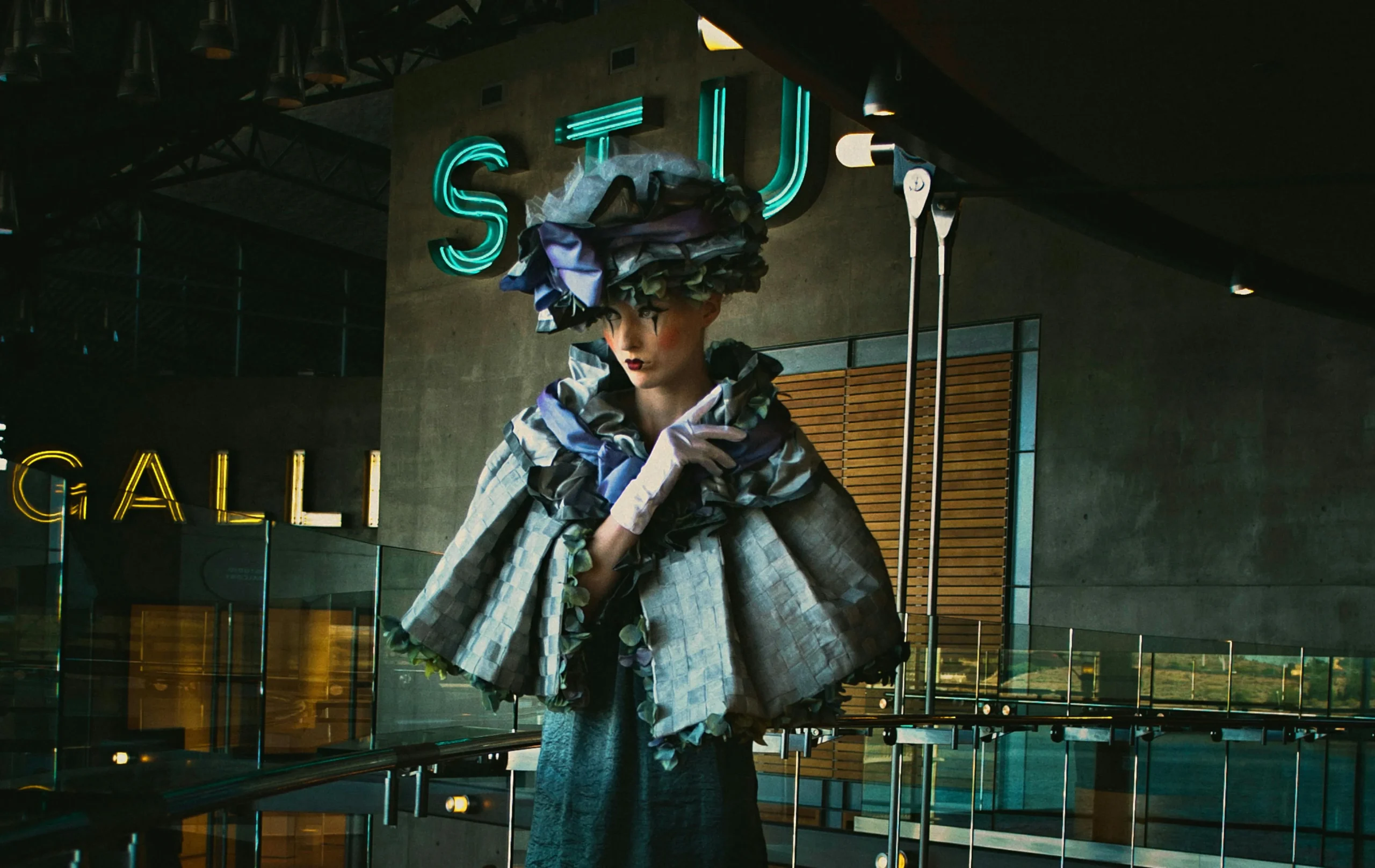 Modella con outfit creativo in contesto museale, interpretazione contemporanea del patrimonio degli archivi della moda